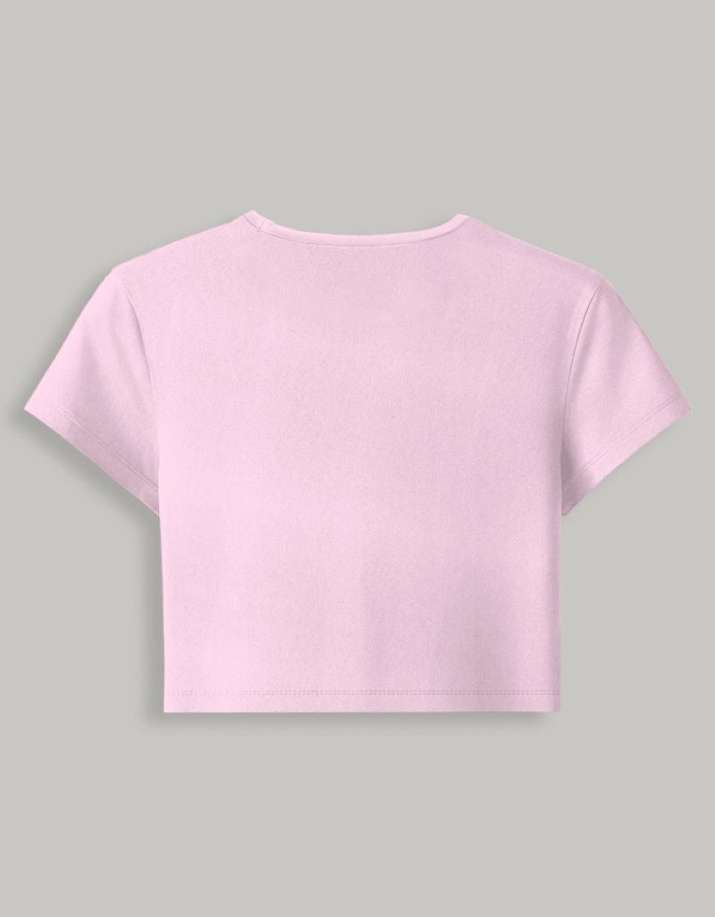 A light pink short-sleeve crop top shown from the back, displayed on a solid gray background.