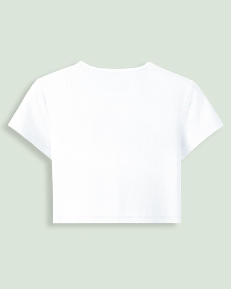 A white short-sleeve crop top shown from the back, centered on a light sage green background.